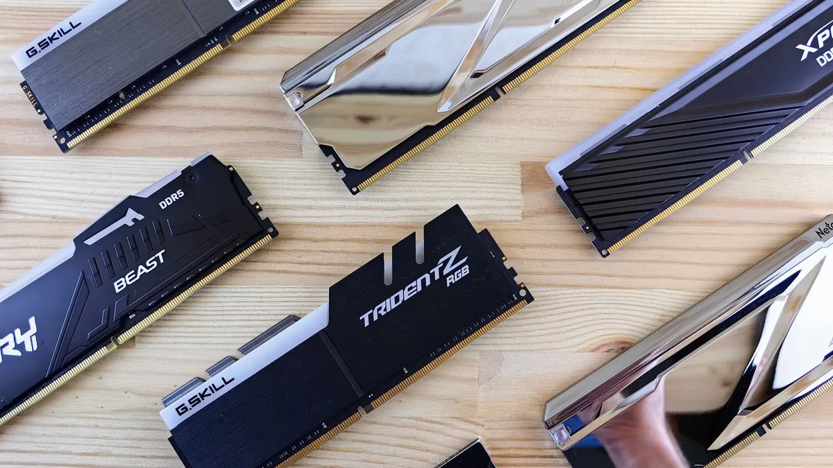 A pair of DDR5 desktop memory modules resting on a wooden surface